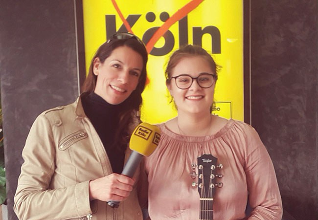 Luna mit Gitarre und Moderatorin
